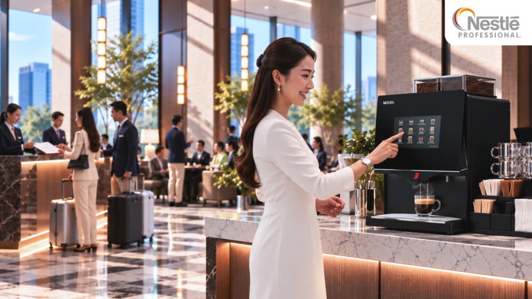 asian woman in white attire using a coffee machine